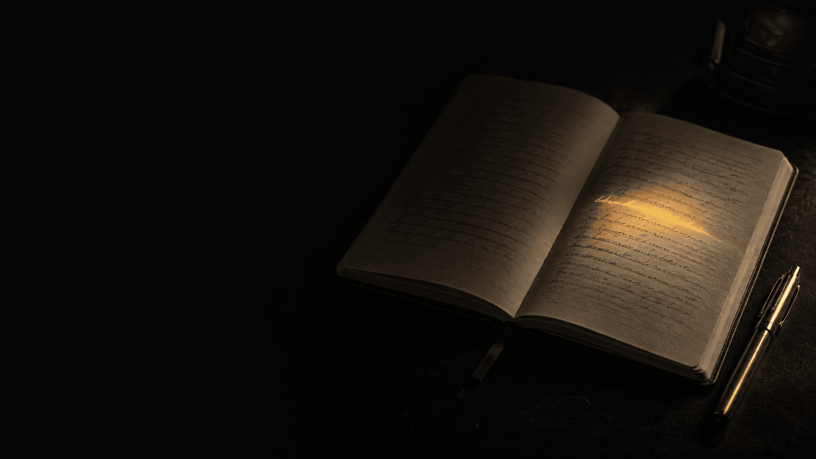 An open notebook and pen on a dark desk, a single line lit in gold